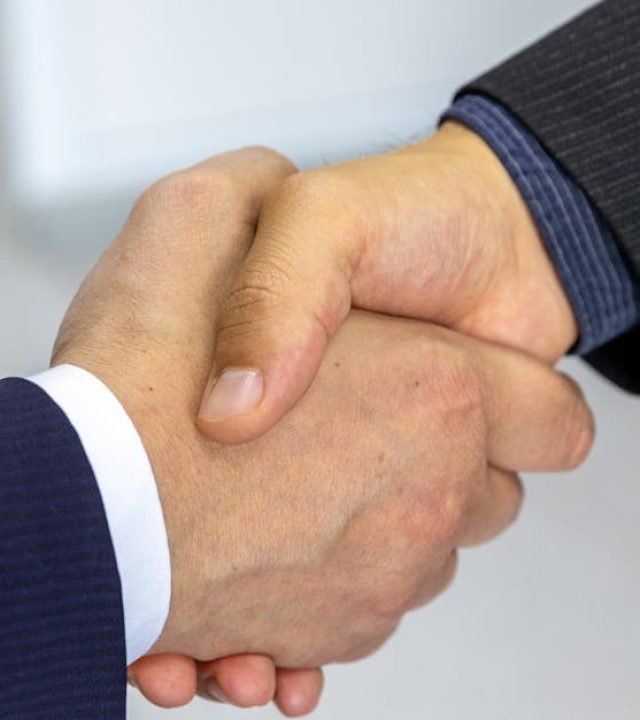 Close-up of two businessmen shaking hands, symbolizing agreement and partnership.